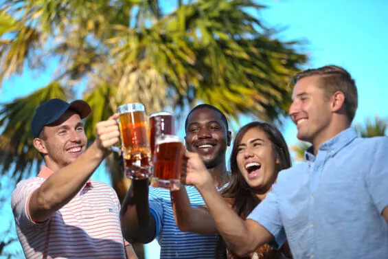 Four people cheers beers.