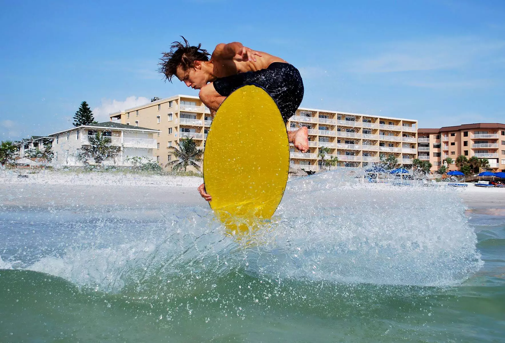 A man catching a wave on a skim board