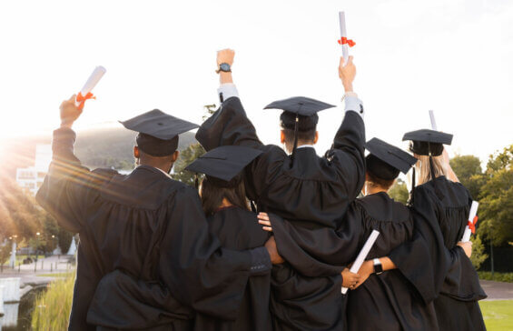Florida students in caps and gowns celebrate graduation holding diplomas