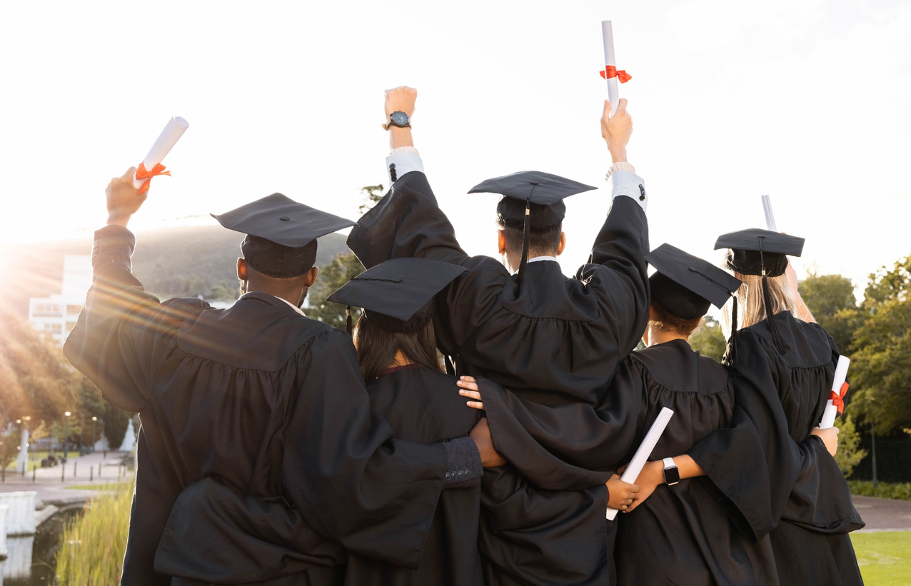 Florida students in caps and gowns celebrate graduation holding diplomas